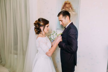 Gelin damat ceket yaka çiçeği koyarak görünümünü yakın çekim.