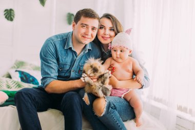 Tavşan tutarak gülümseyen aile yatay portresi.