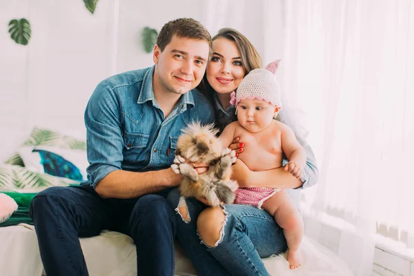 Tavşan tutarak gülümseyen aile yatay portresi.