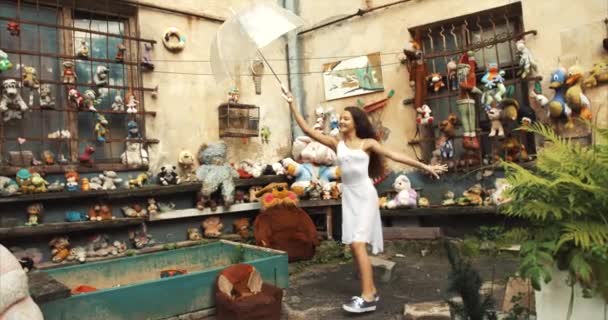 아름 다운 매력적인 소녀는 재미 야외. 그녀는 점프 하 고 오래 된 장난감으로 정원에서 투명 우산 라운드 회전. 4 k. — 비디오