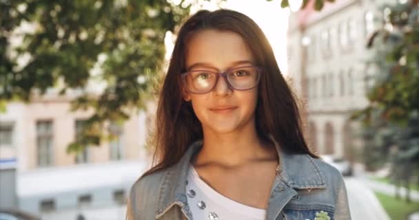 Positiva Bambina Con Lunghi Capelli Scuri Occhiali Viola Sta Sorridendo — Video Stock