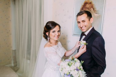 Gülümseyen gelin güzel yaka çiçeği neşeli damat ceket koyuyor