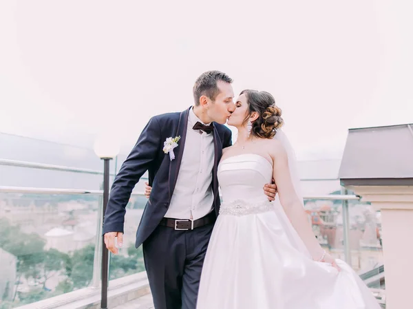 Retrato de cerca de los recién casados besándose bajo el cielo despejado . —  Fotos de Stock