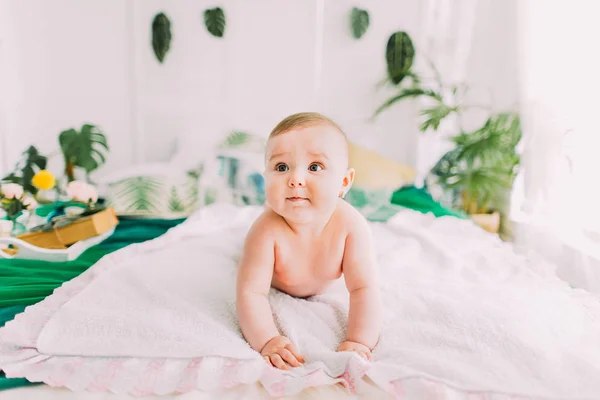 Le portrait horizontal du charmant enfant nu couché sur le plaid blanc . — Photo