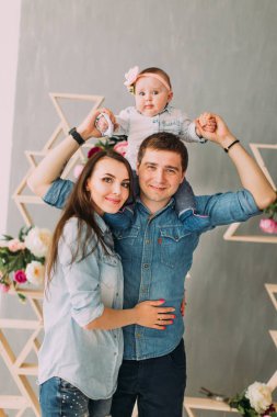 Anne onlara sarılıyor babası holding bebek onun omuzlarında iken.