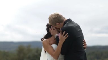 Yeni evliler çekici neşeli çiftin duygusal ortrait evlenmek. Dağlarda öpüşüyorlar şefkatle. Düğün töreni.