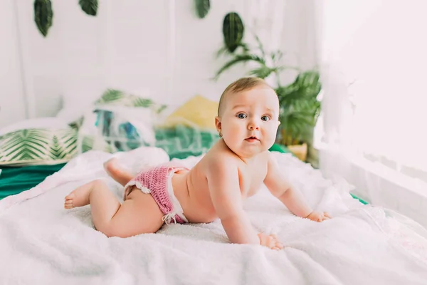 Il ritratto laterale del bambino carino sdraiato sul letto e guardando la fotocamera . — Foto Stock