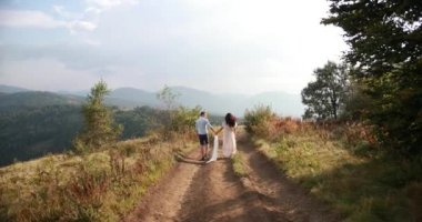 Dağlarda seviyorum. Onlar üzerinde güneş parlar yaparken adam ve woiman yol boyunca ufuk tepede bir yerde çalıştırın.