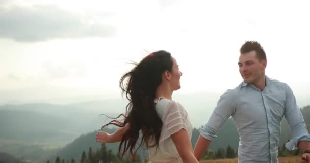 Láska v horách. Muž a woiman jezdí po silnici do obzoru někde na kopci slunce září nad nimi — Stock video