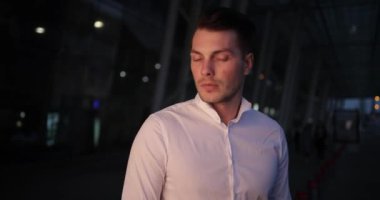 İşadamı bir gezi. Meşgul genç yakışıklı adam etrafında ve dışarıda bir taksi bekleyen onun armwatch görünüyor