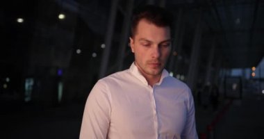 İşadamı bir gezi. Meşgul genç yakışıklı adam etrafında ve dışarıda bir taksi bekleyen onun armwatch görünüyor