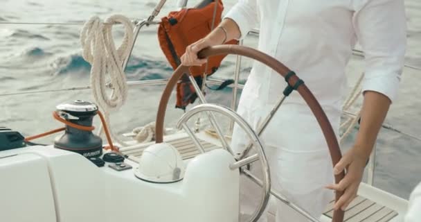 Capitano sullo yacht. Bello uomo barbuto in abiti bianchi tiene le mani sul volante in sella allo yacht dall'altra parte del lago — Video Stock