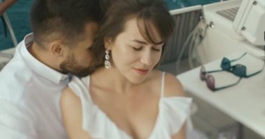 İki yat rahatlatıcı aşık. Kadın ve erkek birbirlerine kendi gezi yatında zevk ihale beyaz giysiler sarılmak giyinmiş