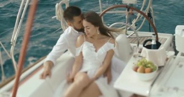 İki yat rahatlatıcı aşık. Kadın ve erkek birbirlerine kendi gezi yatında zevk ihale beyaz giysiler sarılmak giyinmiş