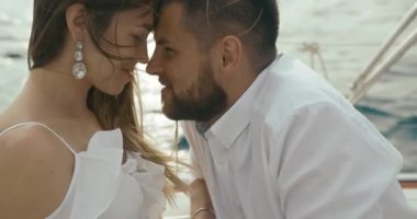 İki yat rahatlatıcı aşık. Kadın ve erkek birbirlerine kendi gezi yatında zevk ihale beyaz giysiler sarılmak giyinmiş