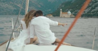 Kaç tekne aşık. Erkek ve kadın Monetengro Kotor Körfezi arasında sürme gemide otururken birbirlerine sarılma arkasından bakmak