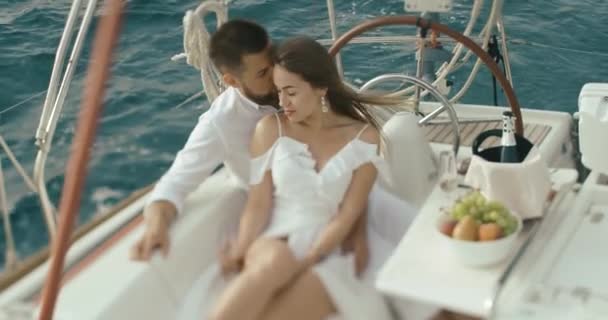 Couple in love relaxing on the yacht. Man and woman dressed in white clothes hug each other tender enjoying their trip on yacht — Stock Video