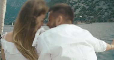 Kaç tekne aşık. Erkek ve kadın Monetengro Kotor Körfezi arasında sürme gemide otururken birbirlerine sarılma arkasından bakmak