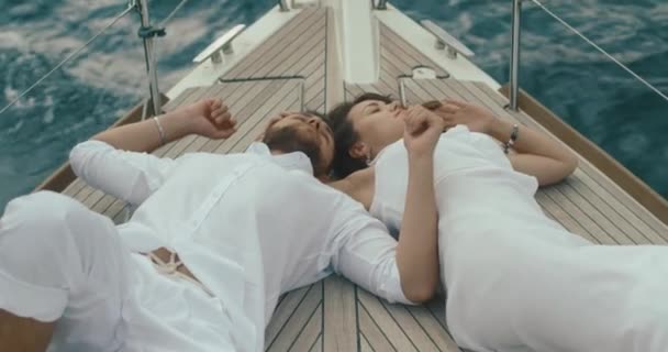 Couple amoureux se détendre sur le yacht. Homme et femme vêtus de vêtements blancs s'embrassent tendrement en profitant de leur voyage sur le yacht — Video