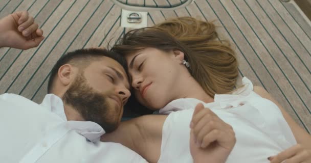 Pár v lásce relaxační na jachtě. Muž a žena oblečená v bílém oblečení objetí navzájem řízení těší jejich výlet na jachtě — Stock video