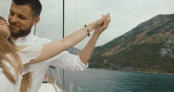 Par i kärlek avkopplande på Lustjakt. Man och kvinna klädd i vita kläder kram varandra anbud njuter av sin resa på yacht — Stockvideo