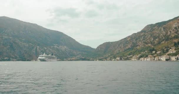 Путешествуйте по Европе. Черногория и Албания. Белая лодка пересекает Которский залив в солнечный день — стоковое видео
