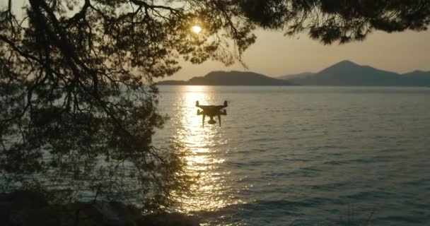 Drone quadcopter met digitale camera vliegen boven het meer of de rivier tegen sky cloud met digitale camera ergens in Montenegro — Stockvideo