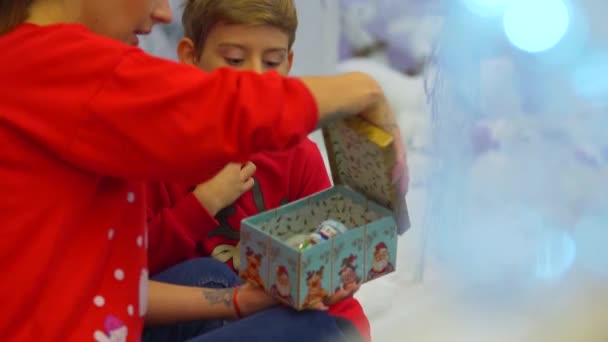 Kerst preparetions. Moeder en zoon kijken winter vakantie speelgoed permanent in het winkelcentrum — Stockvideo
