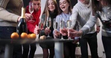 Yeni yıl kutlama. Kızlar ve erkekler kendi gözlük ile Noel ağacı ile odada şampanya ayakta içime