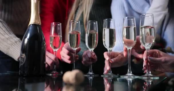 New Year celebration. People dance on the background while camera focuses on the champagne flutes — Stock Video