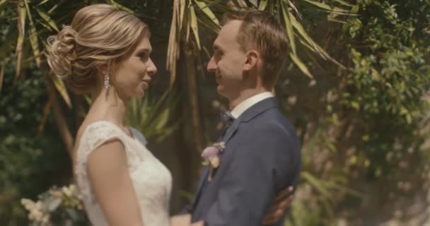 Mariage au Monténégro. Cérémonie européenne traditionnelle. Matin avant la réception. 4k. Époux câlins tendre belle mariée blonde debout à l'extérieur — Video