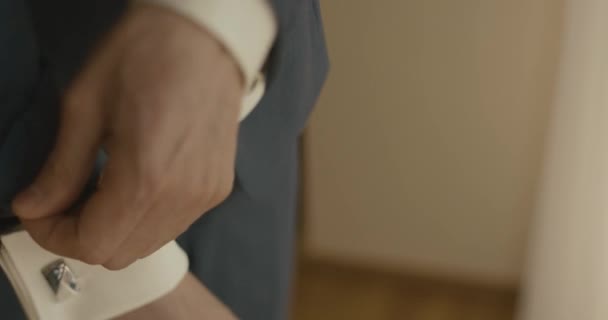 Mariage au Monténégro. Cérémonie européenne traditionnelle. Matin avant la réception. 4k. Des hommes d'affaires. Gros plan des mains de mans pendant qu'il fixe son costume bleu 