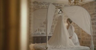 Karadağ düğünde. Geleneksel Avrupa kabul töreni. Resepsiyon sabaha. 4 k. gelin narin ipek elbise içinde çok beğendiği bir otel odasında ayakta onu gelinlik