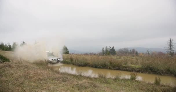 Lazer na montanha. Vocações de outono. Etreme. Carro off-road Nissan Patrol dirige rápido para o pântano na colina em algum lugar nas montanhas do outono — Vídeo de Stock