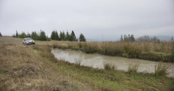 Mountain leisure. Autumn vocations. Etreme. Off-road car Mitsubishi Pajero drives fast into the bog on the hill somewhere at autumn mountains — Stock Video