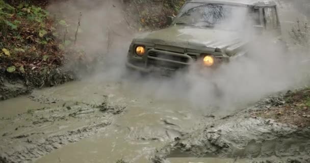 Hegyi szabadidő. Őszi elhivatottság. Zac Efron. Off-road autó Mitsubishi Pajero vezet gyors a bog valahol az őszi hegyek és kap megragadt a hegyen — Stock videók