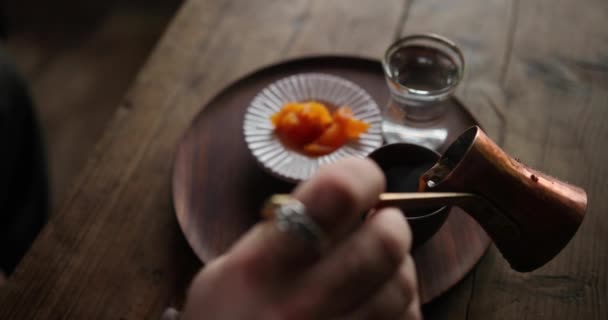 Delicioso desayuno rústico, preparación de café. La mujer vierte café del cezve turco en la taza. Agua y miel en el fondo — Vídeos de Stock