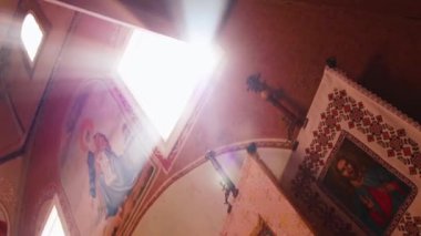 Ortodoks, Hıristiyanlık, kilise. Duvardaki dini sanat ile eski bir kilise penceresinde tepesinden güneş parlıyor.