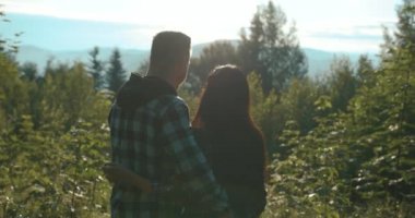 Dağ ülke lovestory. 4 k. adam ve kadın uzun otların ile araziyi yürüyüş akşam ışıklar keyfini çıkarın