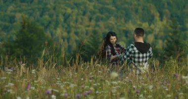 Dağ lovestory. 4 k. adam ve kadın benzer onay gömlek fırtınası alanı ile uzun otların bir yere dağlarda giyinmiş
