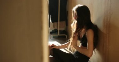 Depresyon konsepti. Uzun koyu saçlı Genç kadın iç çamaşırı yerde oturur ve ağlıyor