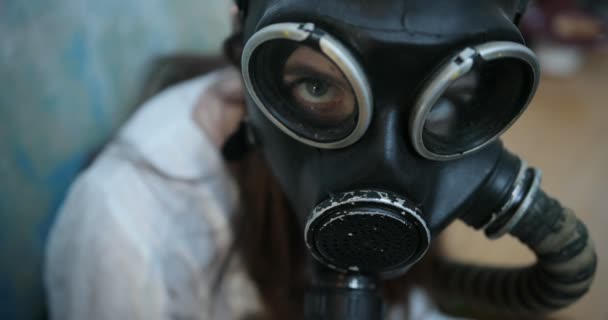 Mira desde arriba a una joven con máscara de gas sentada en el suelo — Vídeos de Stock