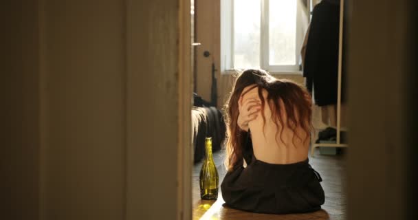 Slachtoffer en ziekte concept. Huilende jonge vrouw krassen zelf zittend op de vloer in de kamer en huilen, drinken wijn — Stockvideo