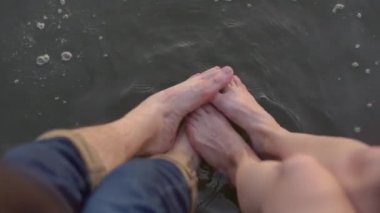 Aşk aşık tatlı gülümseyen romantik çift sarılma ve Central Park ortasında öpüşme. iskelede oturan ve bacaklar tarafından su sıçramaları yapma. Randevu, şirinlik, gerçek aşk. Neşeli ruh hali, mutluluk
