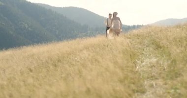 Karpat Dağları 'nda genç güzel bir çift. Güneşli bir gün romantik dating veya lovestory. Atmosferik. 4k.