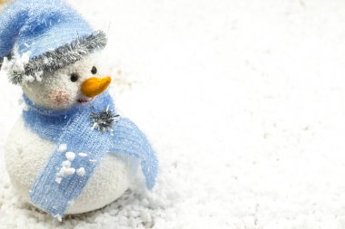 Karda mavi şapkalı bir kardan adam. Metin için yer