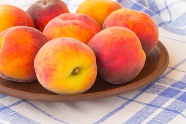 Şeftali bir mavi ve beyaz masa örtüsü üzerinde