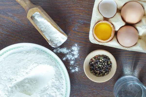 Bir kase ve bir tahta kaşık un. Tavuk yumurtası. Bardak su