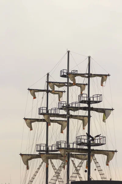 Mast ship on a background of gray sky