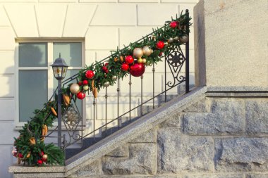 Korkuluk çam dalları ve kırmızı topları ile dekore edilmiştir. Bina cephe parçası